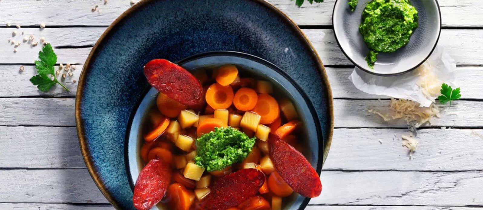 Färgglad morots-ingefärs-gryta med grön pesto och knaperstekt chorizo