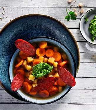 Färgglad morots-ingefärs-gryta med grön pesto och knaperstekt chorizo