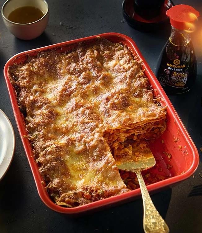 Lasagne med linser och grönsaker stuvade i sojasås, med parmesan och svart sesam